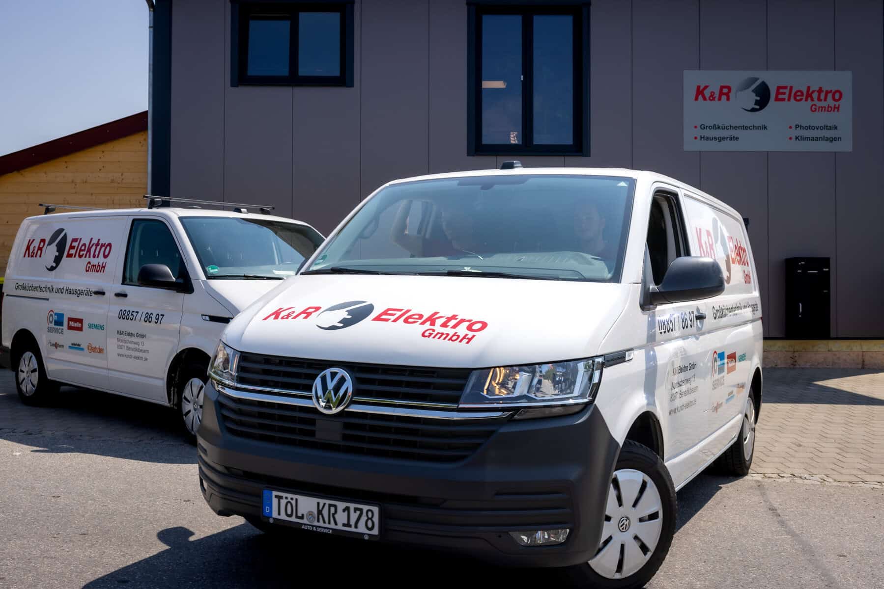 Firmenfahrzeuge von K&R Elektro GmbH vor Firmengebäude.