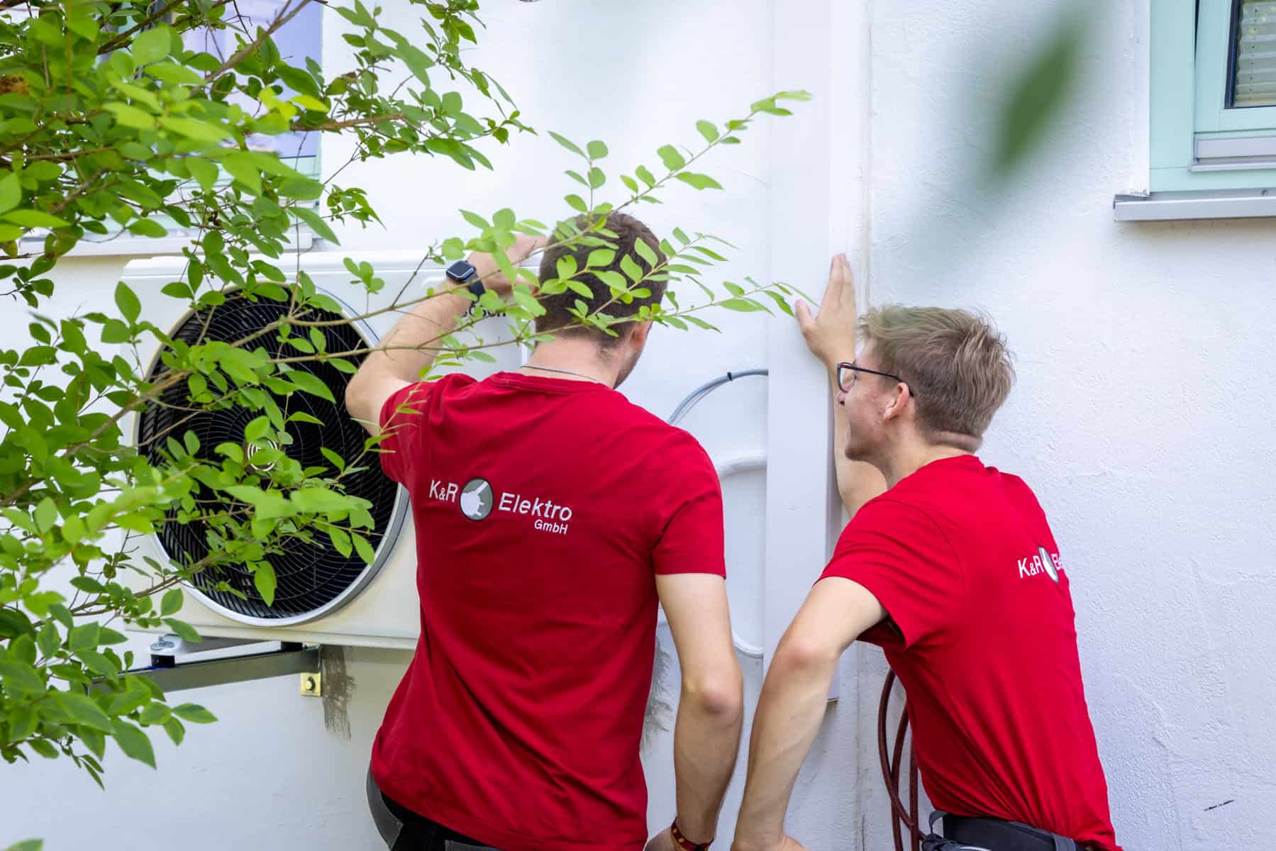 Elektroinstallateure bei der Arbeit an Außenwandinstallation.