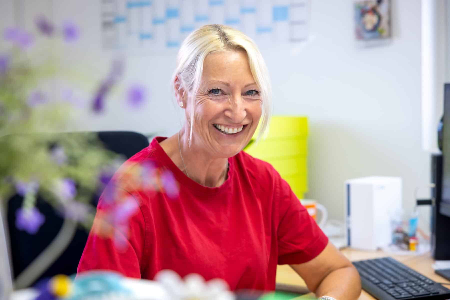 Lächelnde Frau in rotem T-Shirt bei K&R Elektro GmbH.