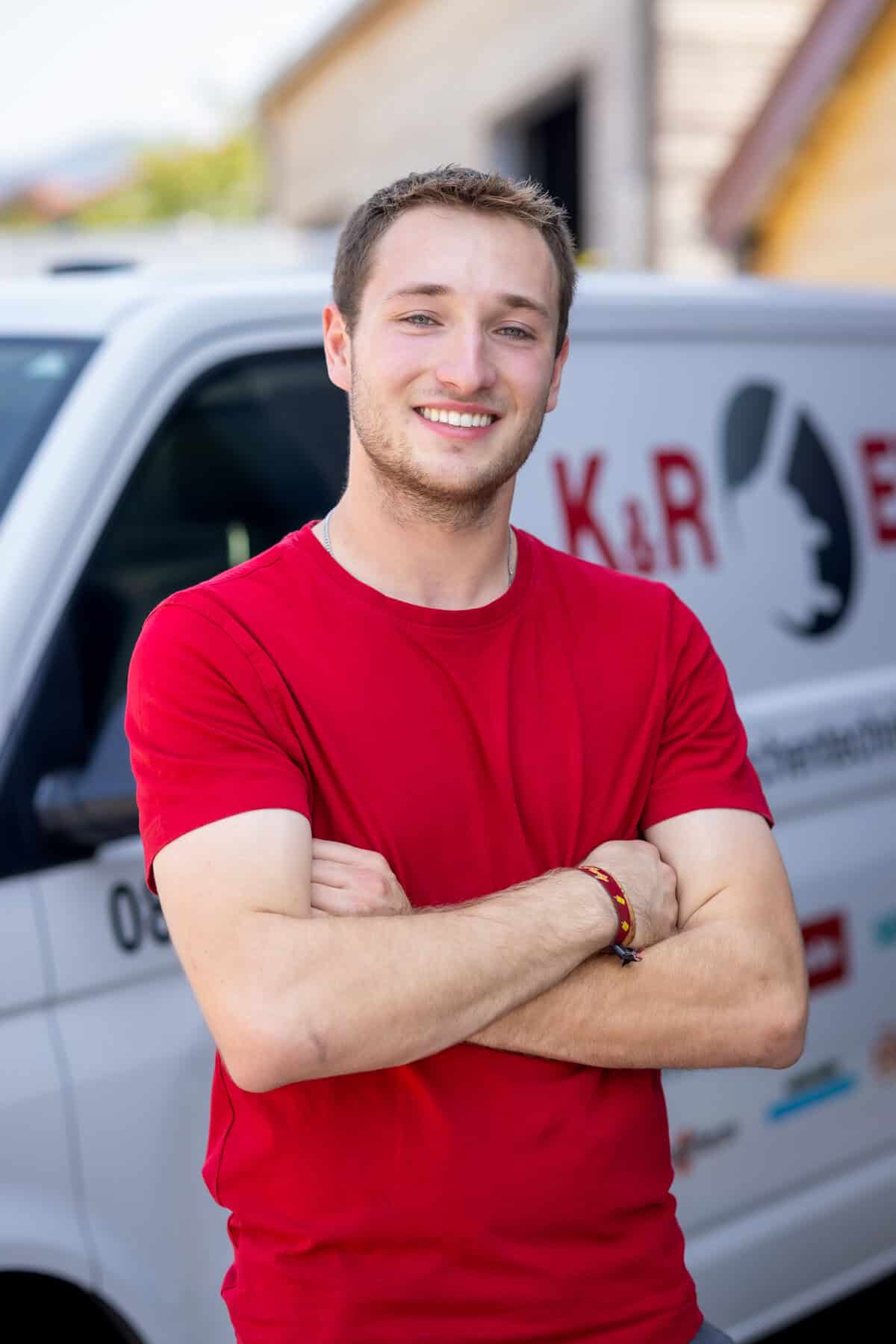 Elektriker von K&R Elektro GmbH vor Firmenfahrzeug mit Logo.