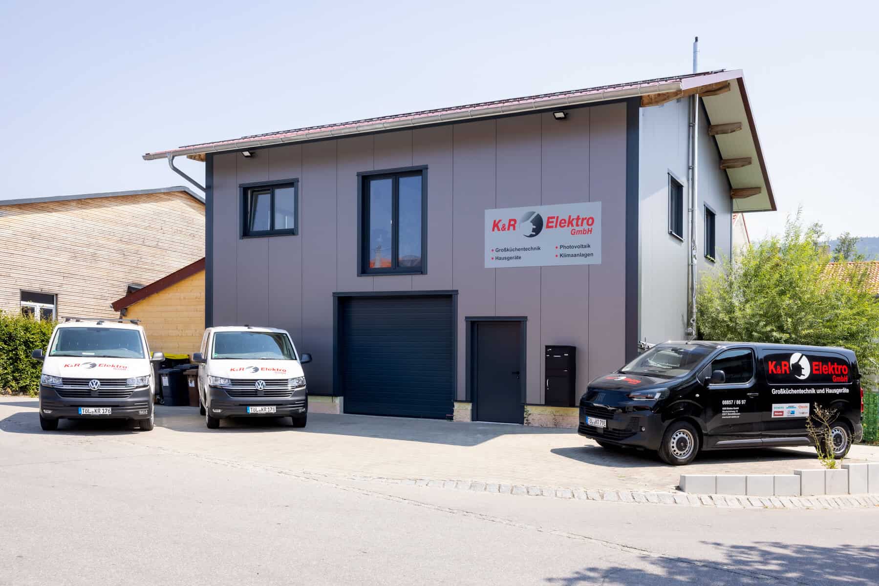 Firmengebäude von K&R Elektro GmbH mit Firmenlogo und Fahrzeugen.