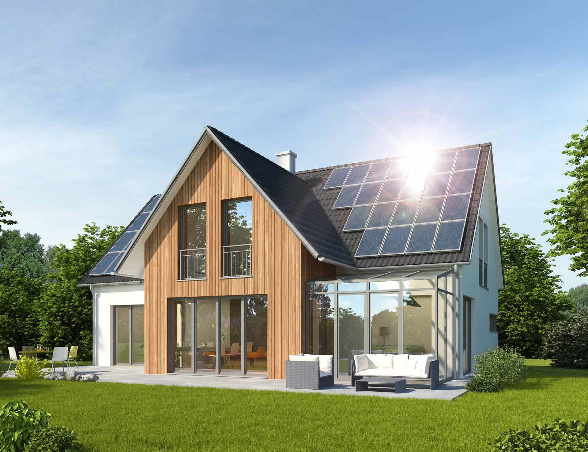 Haus mit Solarpanelen auf dem Dach und großen Fenstern.